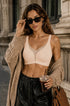 Skin-tone wireless deep V bra with wide straps and smooth, lightly padded cups.